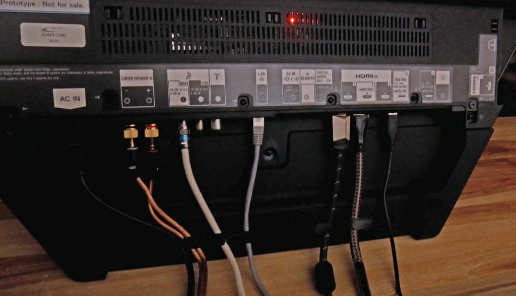 Die Anschlüsse des AF9 befinden sich am Standfuß und verschwinden komplett hinter einer Abdeckung aus Stoff. Folgende Anschlüsse sind vorhanden: 4x HDMI 2.0 (einer mit eARC), optisch-digital Audio, AV-Eingang, Ethernet, Kabel + Twin-Satelliten-Tuner. Zusätzlich ein Aux-Eingang für den Center-Speaker-Modus