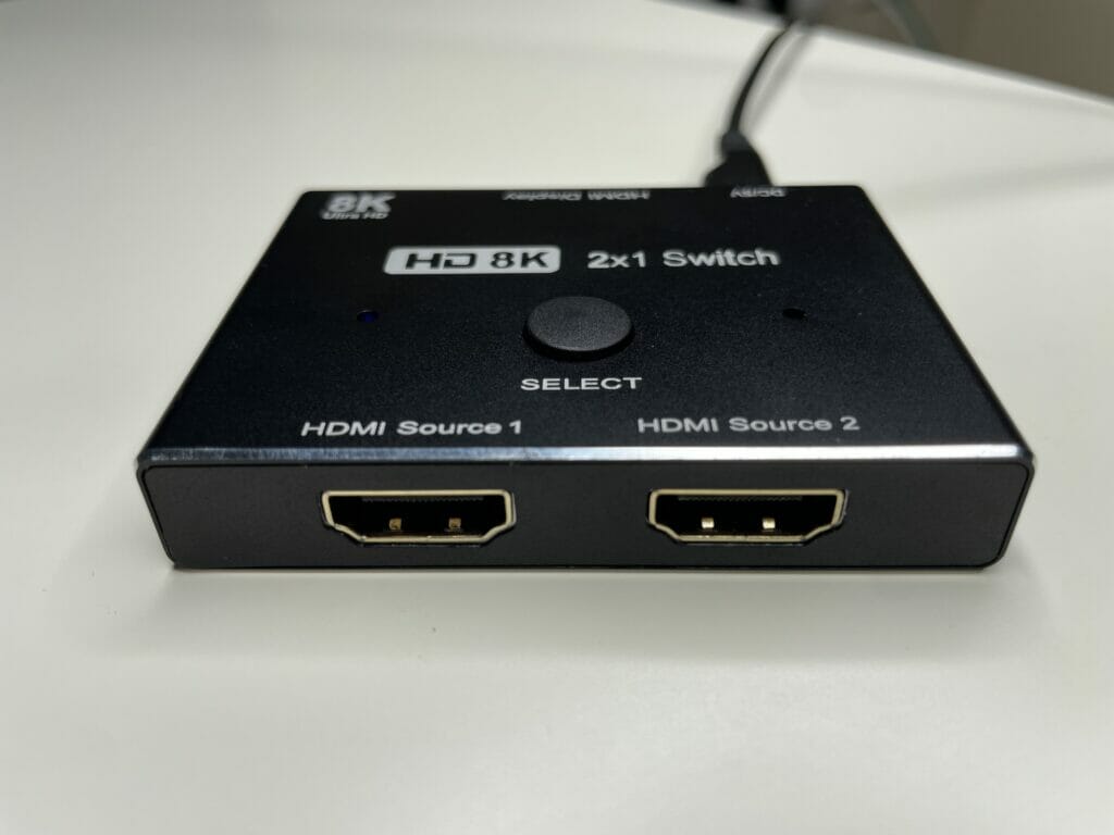 El interruptor tiene dos entradas HDMI 2.1.  Hay un botón de cambio de fuente de señal e indicadores LED en la parte superior