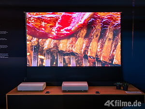 Der The Premiere 9 4K-UST-Laser-Projektor in Aktion, daneben der The Premiere 7 mit Single-Laser-Lichtquelle.