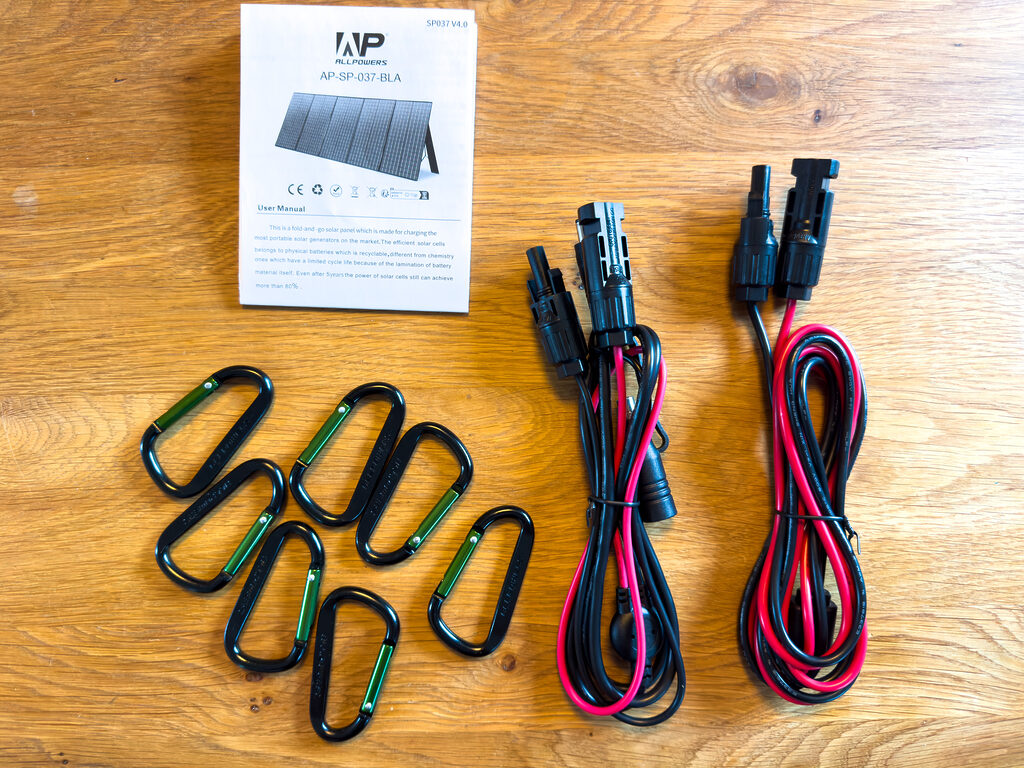 Der Lieferumfang des SP-037 400 Watt Solarpanels ist überschaubar. Neben dem Panel gibt es zwei Verbindungskabel zur Akkubox, Kletterhaken für eine hängende Installation und eine Bedienungsanleitung. Der R1500 PowerStation liegt nur ein zusätzlicher Kaltgerätestecker bei.