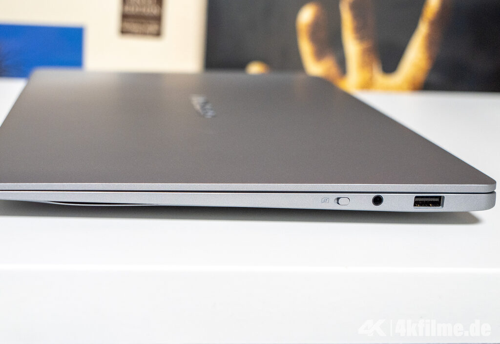 Anschlüsse auf der linken Seite: USB 2.0 (Typ-A), ein kombinierter Mikrofon-/Koprhöreranschluss + An/Aus-Taste für die Webcam.