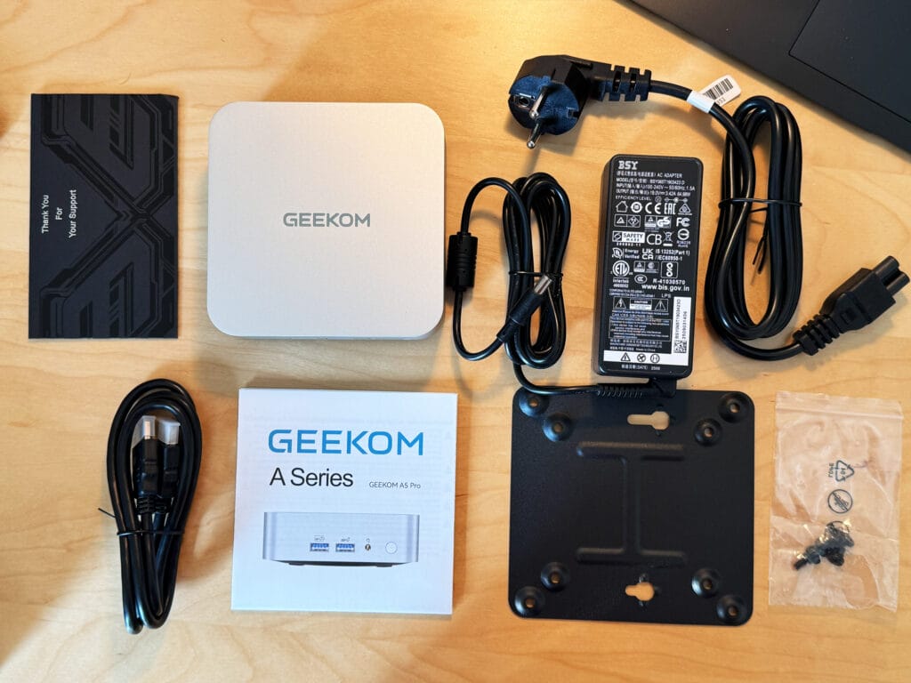 Der Lieferumfang des Geekom A5 Pro (2026 Edition) mit Mini PC, Netzteil, Netzstecker, HDMI 2.0-Kabel, Monitor-Halterung und einer Betriebsanleitung