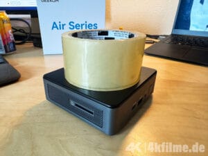 Zum Vergleich, der Geekom Air12 2026-Edition Mini-PC im Größenvergleich mit einer handelsüblichen Rolle Klebeband.